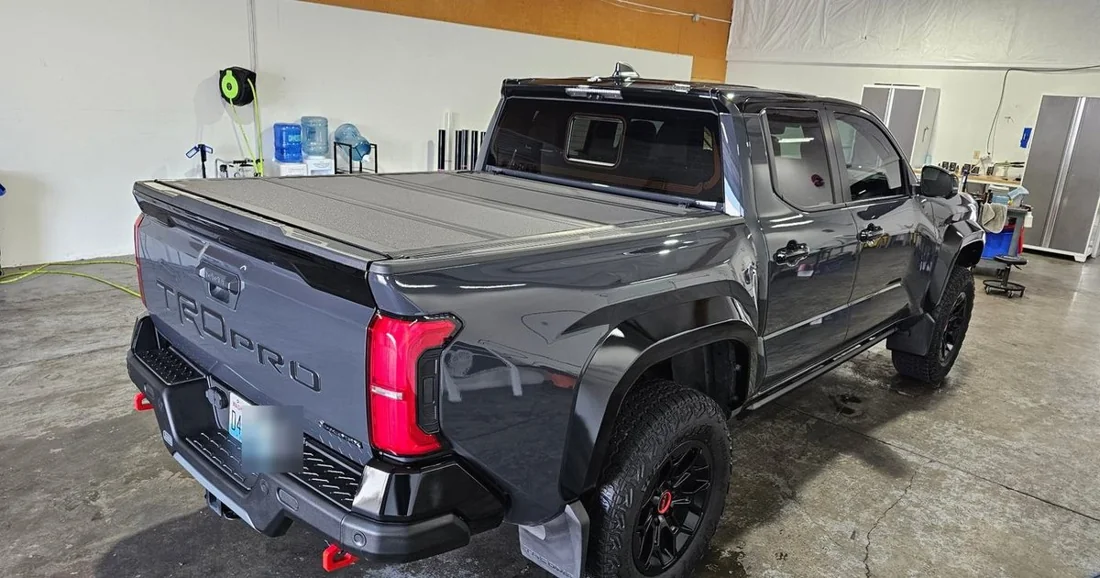 Gray pickup truck in the APC Auto Spa shop, showing its tailgate, bed edges and side panels